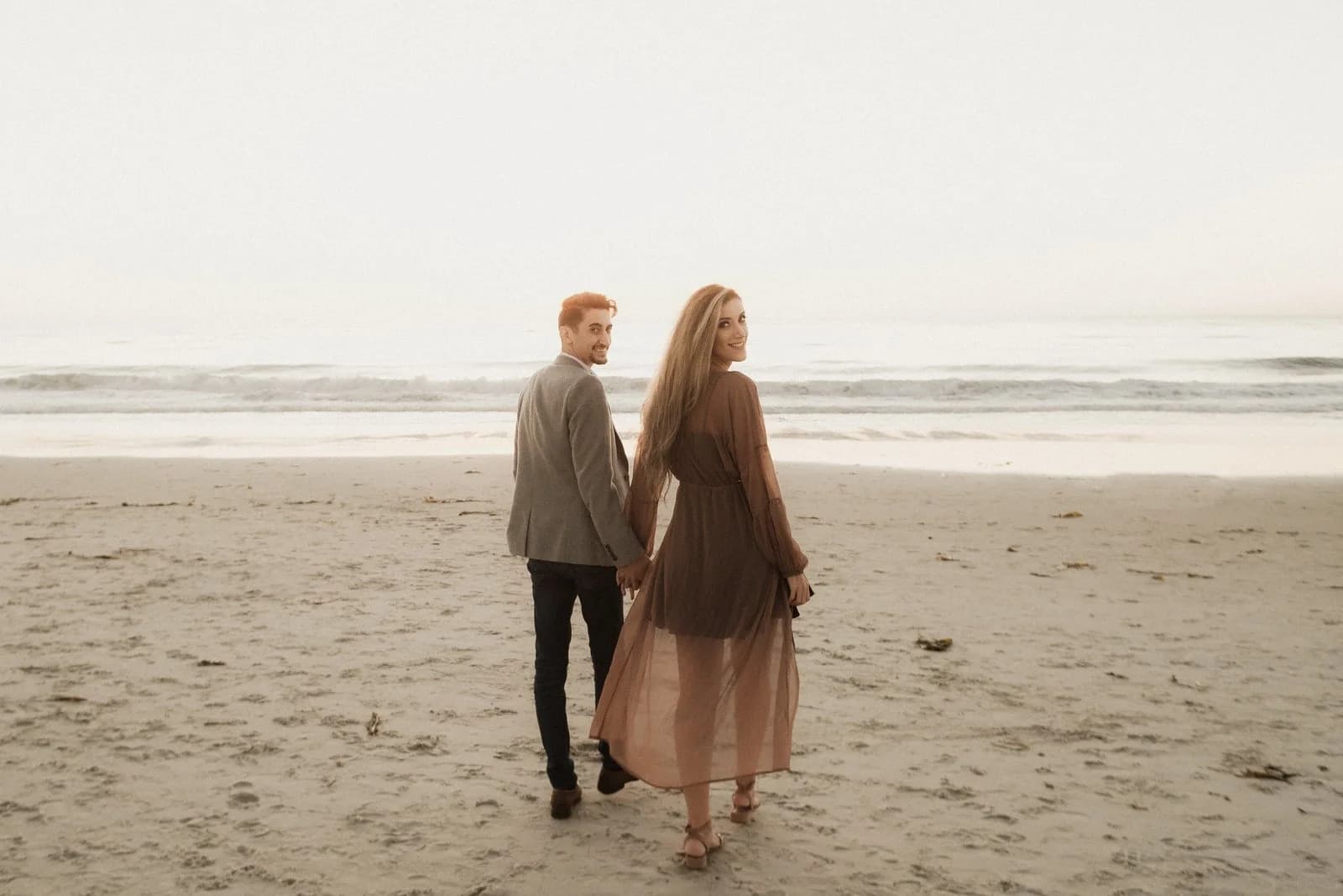 Couple walking the shoreline at dusk — couples photography by Steven Lelham in California coast