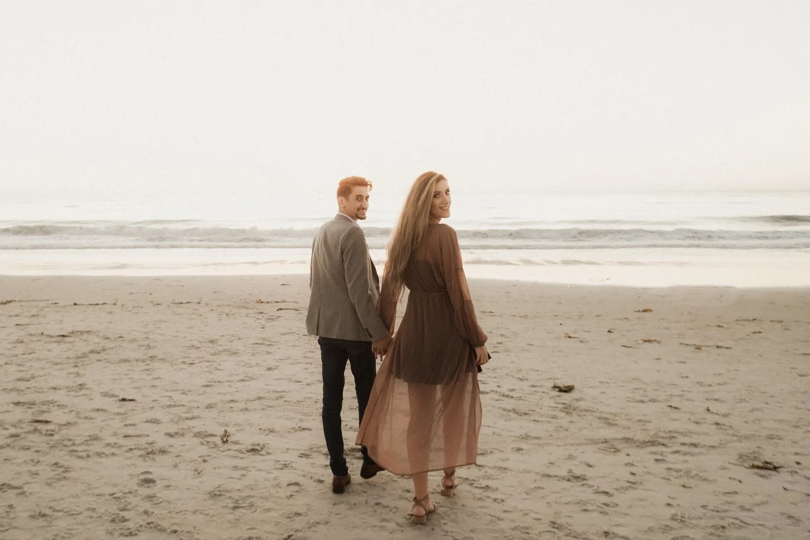 Couple walking the shoreline at dusk — couples photography by Steven Lelham in California coast